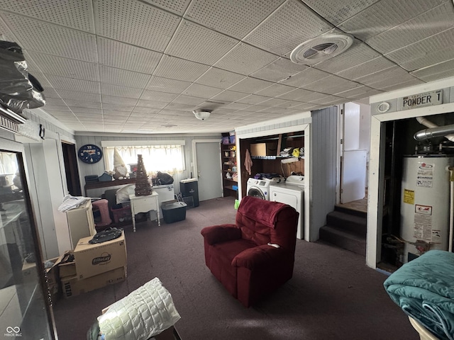 carpeted living room with water heater and washing machine and clothes dryer