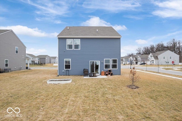 back of property with a lawn and a patio area