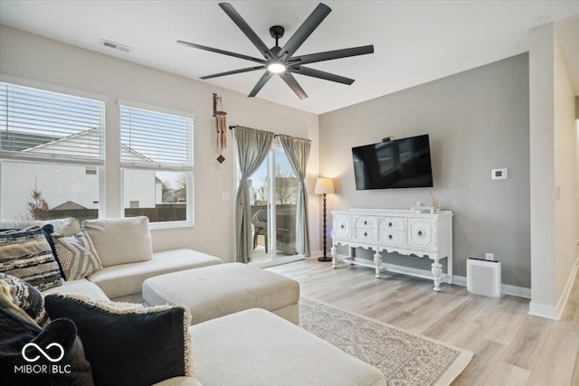 living room with light hardwood / wood-style flooring and ceiling fan