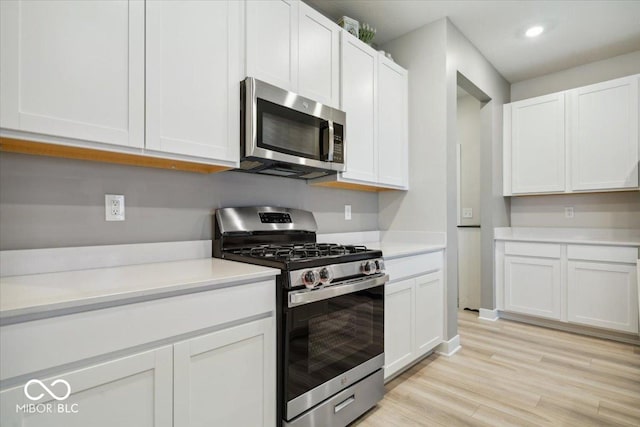 kitchen featuring white cabinetry, appliances with stainless steel finishes, and light hardwood / wood-style flooring