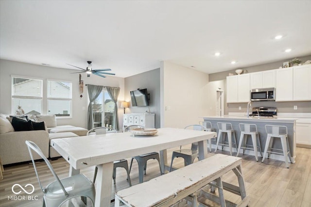 dining space featuring ceiling fan and light wood-type flooring