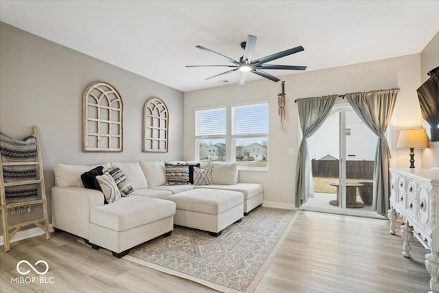 living room with light hardwood / wood-style flooring and ceiling fan