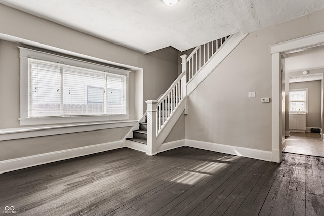 staircase with hardwood / wood-style flooring and a textured ceiling