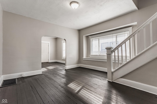 interior space with dark wood-type flooring and a textured ceiling