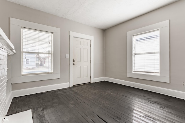 foyer featuring dark wood-type flooring and a textured ceiling