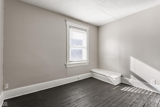 unfurnished room featuring dark hardwood / wood-style flooring and a textured ceiling