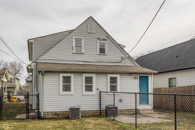 back of house with a yard and central air condition unit