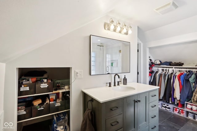 bathroom featuring lofted ceiling and vanity