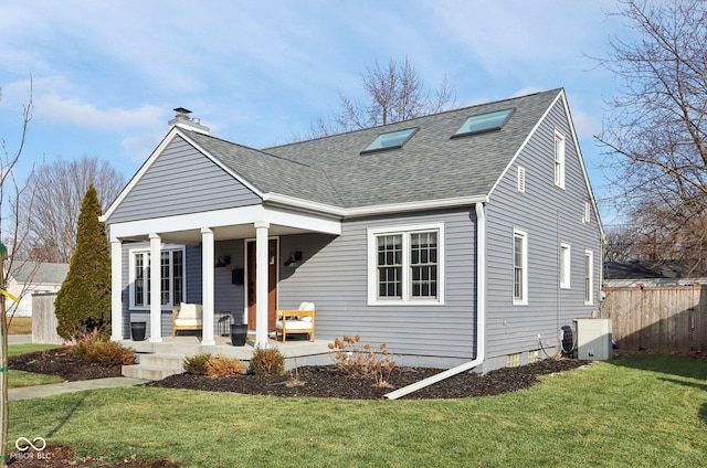 view of front of house with a front lawn, central air condition unit, and covered porch