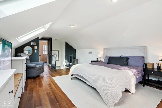 bedroom featuring lofted ceiling with skylight and dark hardwood / wood-style flooring