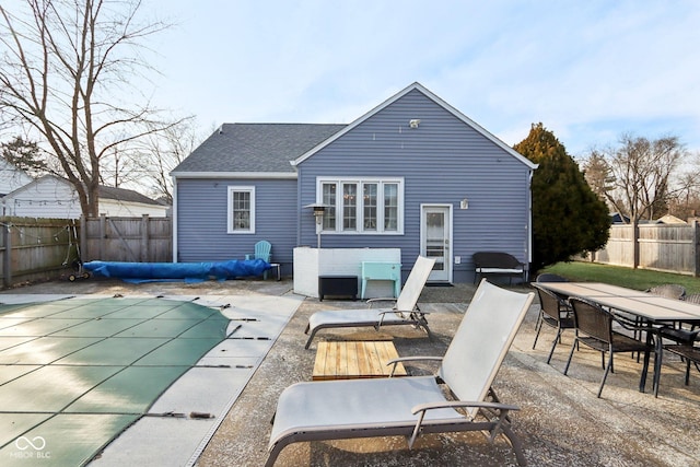 back of property with a patio area and a covered pool