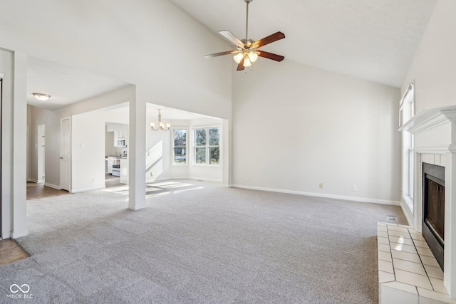 unfurnished living room featuring light carpet, ceiling fan with notable chandelier, and high vaulted ceiling