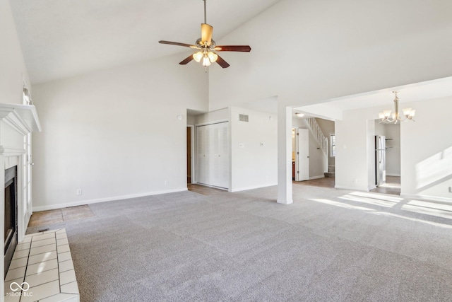 unfurnished living room with ceiling fan with notable chandelier, carpet floors, and high vaulted ceiling