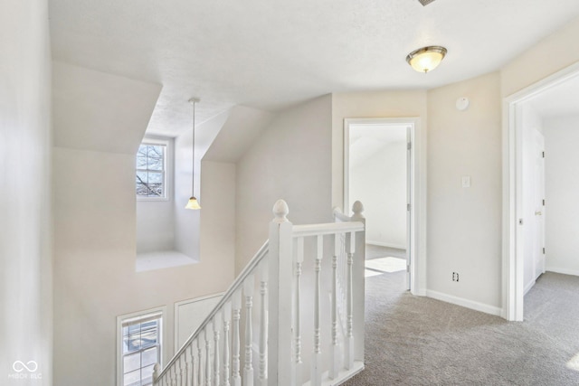 corridor with vaulted ceiling and carpet flooring