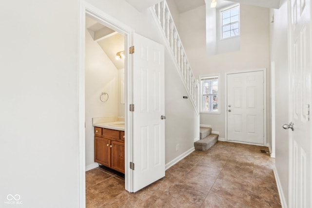 bathroom featuring vanity, a healthy amount of sunlight, and a high ceiling