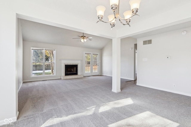 unfurnished living room with a tiled fireplace, vaulted ceiling, carpet flooring, and ceiling fan with notable chandelier