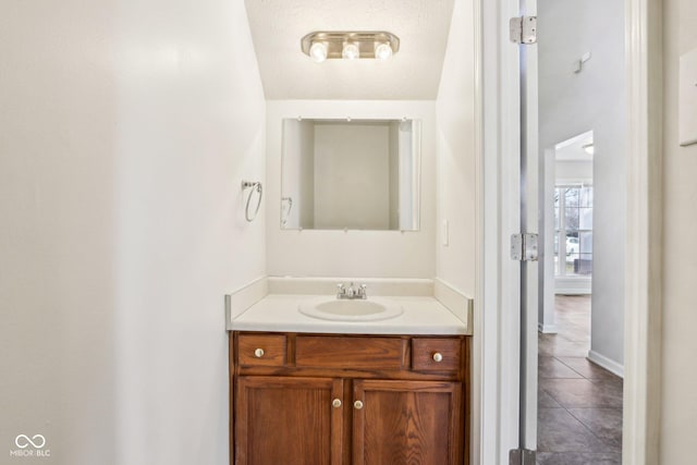 bathroom featuring tile patterned flooring, vanity, and a textured ceiling