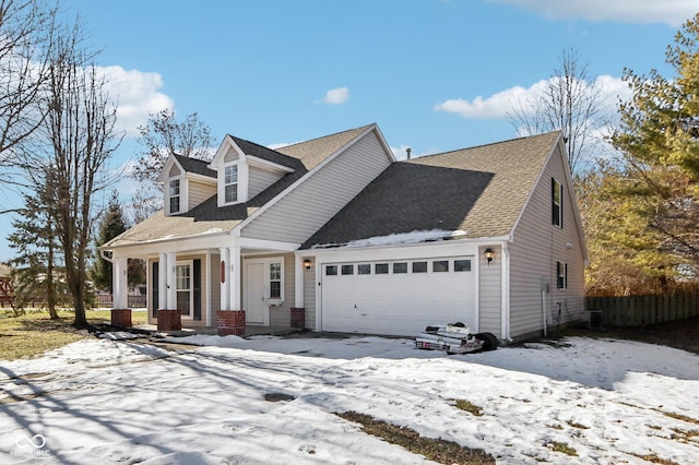 cape cod-style house featuring a garage and covered porch