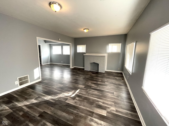 unfurnished living room with a fireplace and dark hardwood / wood-style flooring