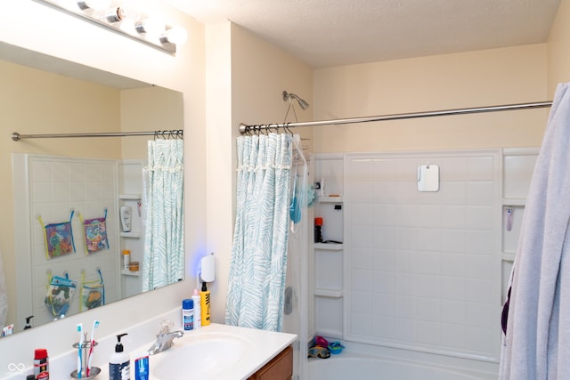 bathroom featuring vanity, shower / tub combo with curtain, and a textured ceiling