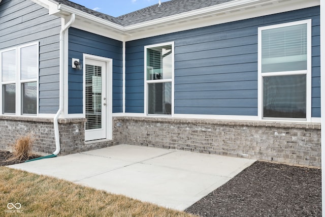 view of exterior entry featuring a patio area