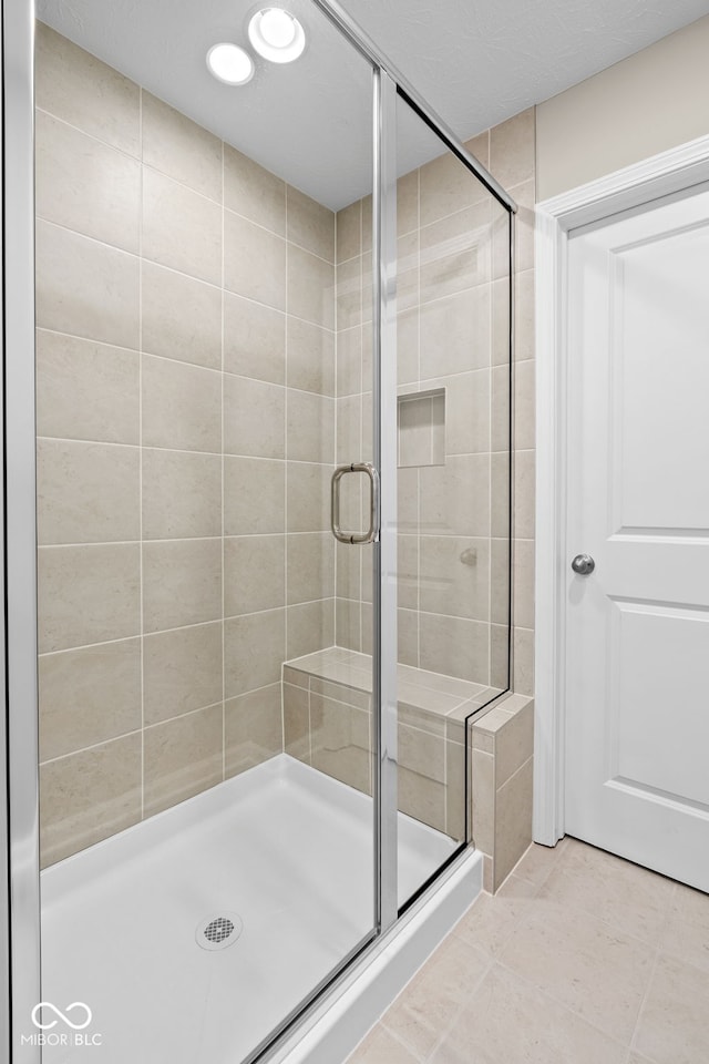 bathroom with tile patterned flooring and walk in shower