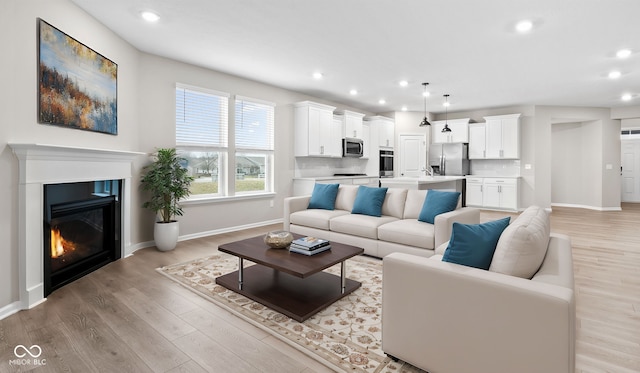 living room with sink and light wood-type flooring