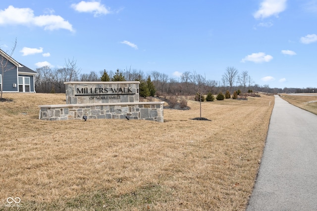 community / neighborhood sign with a rural view and a yard