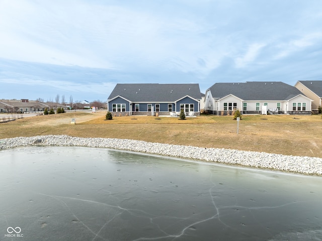 exterior space featuring a water view and a front lawn