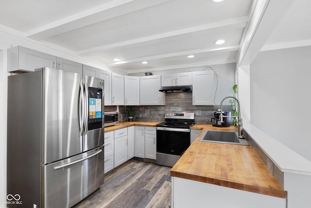 kitchen with sink, butcher block countertops, appliances with stainless steel finishes, beamed ceiling, and decorative backsplash