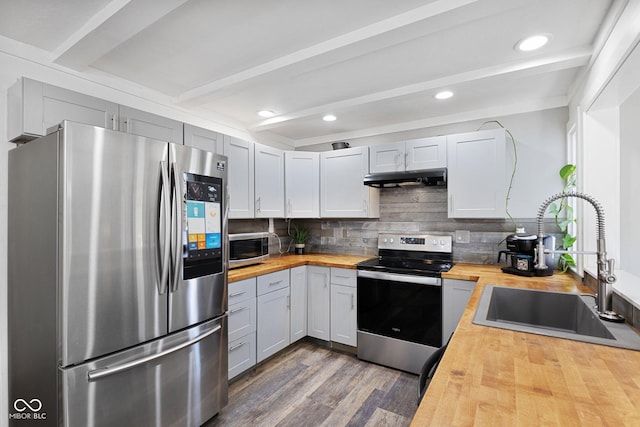 kitchen featuring sink, tasteful backsplash, wooden counters, beamed ceiling, and stainless steel appliances