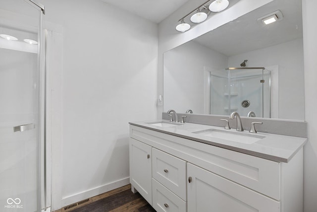 bathroom featuring hardwood / wood-style flooring, vanity, and a shower with shower door