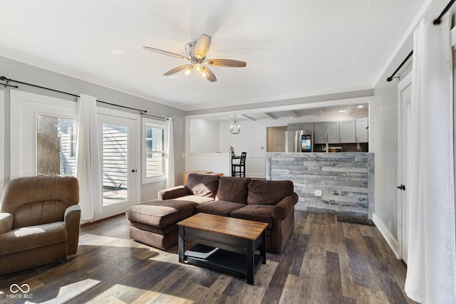 living room featuring dark hardwood / wood-style floors and ceiling fan with notable chandelier