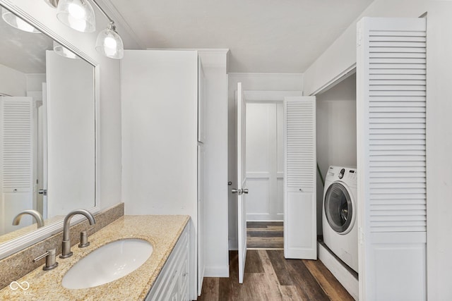 bathroom with washer / clothes dryer, vanity, and hardwood / wood-style floors