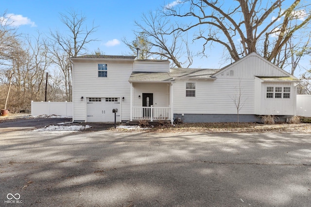 back of house with a garage and a porch