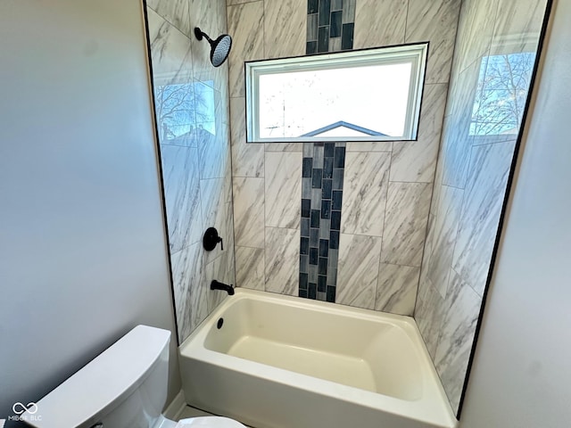 bathroom featuring toilet and tiled shower / bath