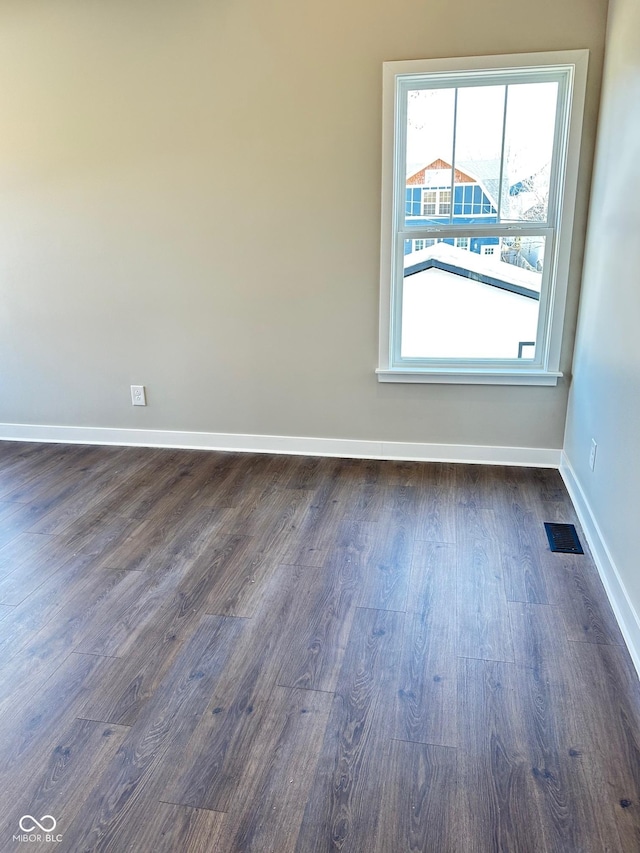 spare room with dark wood-type flooring