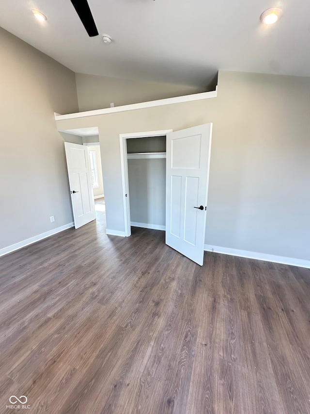 unfurnished bedroom featuring dark hardwood / wood-style flooring, vaulted ceiling, a closet, and ceiling fan