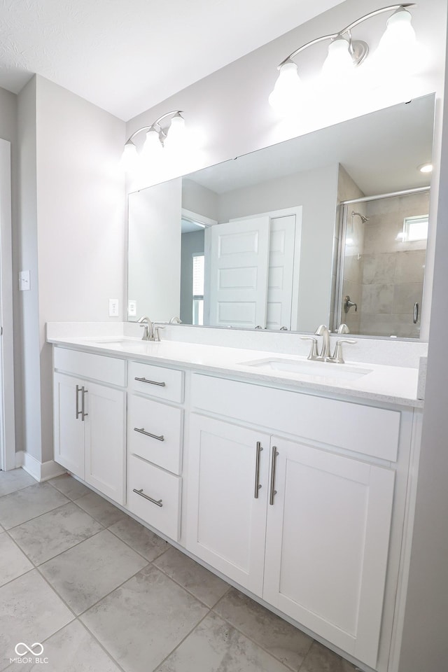 full bathroom with double vanity, a stall shower, marble finish floor, and a sink