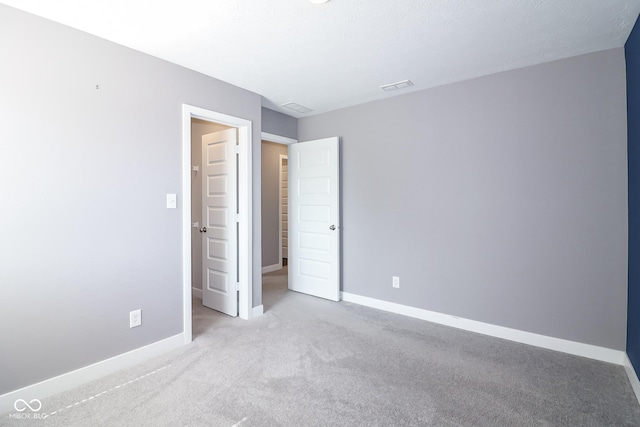 unfurnished bedroom with visible vents, baseboards, and carpet floors