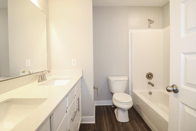 full bath featuring toilet, double vanity, shower / bathing tub combination, wood finished floors, and a sink