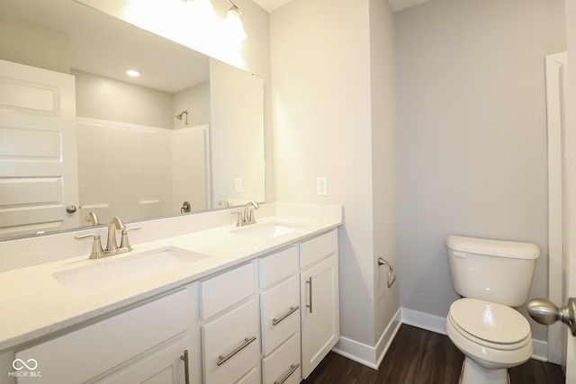 full bathroom featuring a sink, baseboards, toilet, and wood finished floors