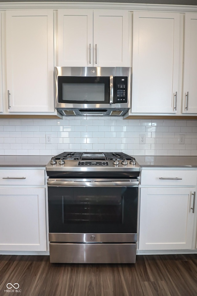 kitchen with backsplash, dark wood-type flooring, appliances with stainless steel finishes, and white cabinetry