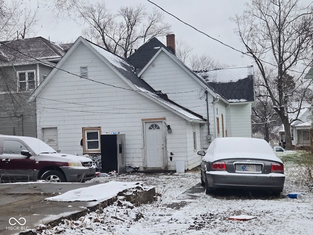 view of front of property with a shingled roof and a chimney