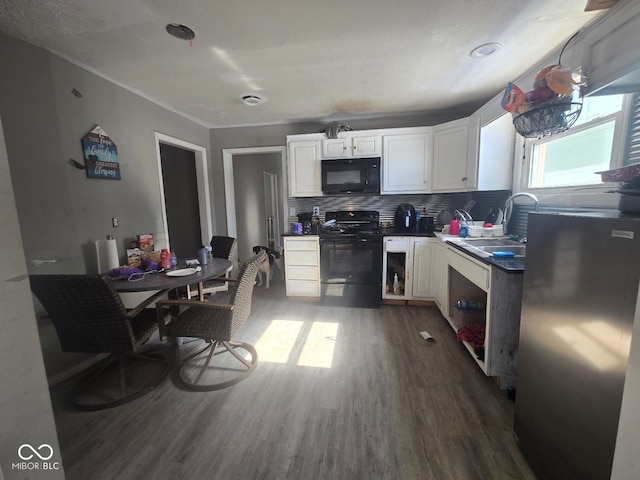 kitchen featuring a sink, white cabinets, dark wood-style floors, black appliances, and dark countertops