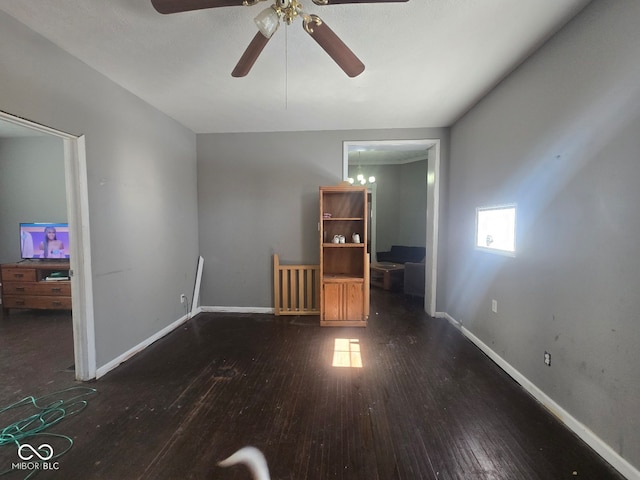 unfurnished room with baseboards and dark wood-type flooring