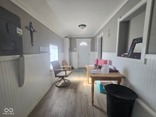 entrance foyer with a wainscoted wall, crown molding, visible vents, and wood finished floors