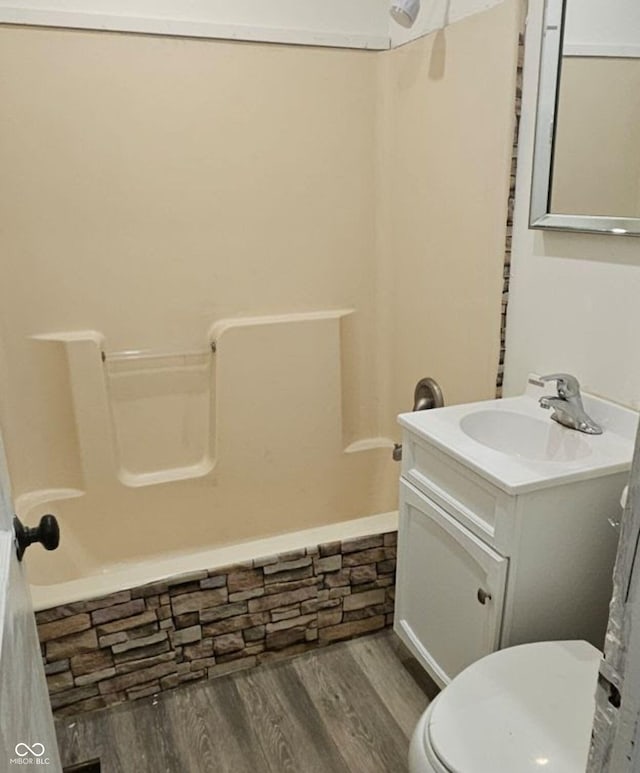 bathroom with toilet, vanity, wood finished floors, and shower / bathing tub combination