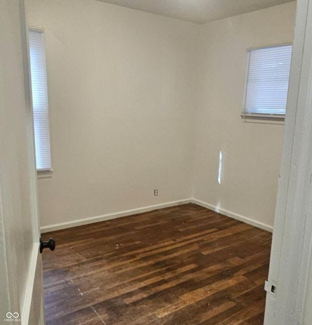 unfurnished room with dark wood-type flooring