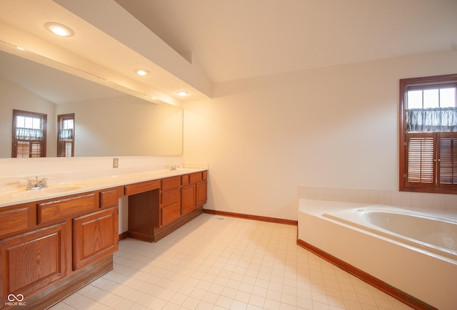 bathroom with lofted ceiling, vanity, and a bathing tub